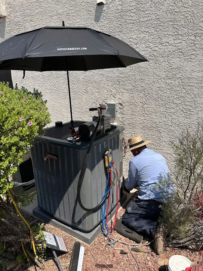 HVAC technician performing outdoor AC maintenance in Fulton