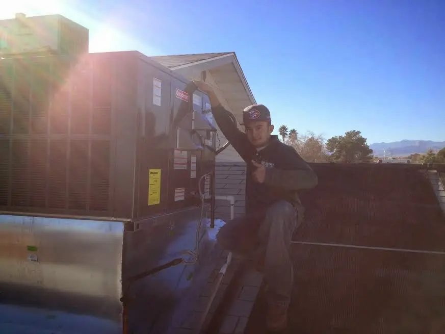 HVAC technician performing Air Duct Cleaning on a rooftop unit in Fulton
